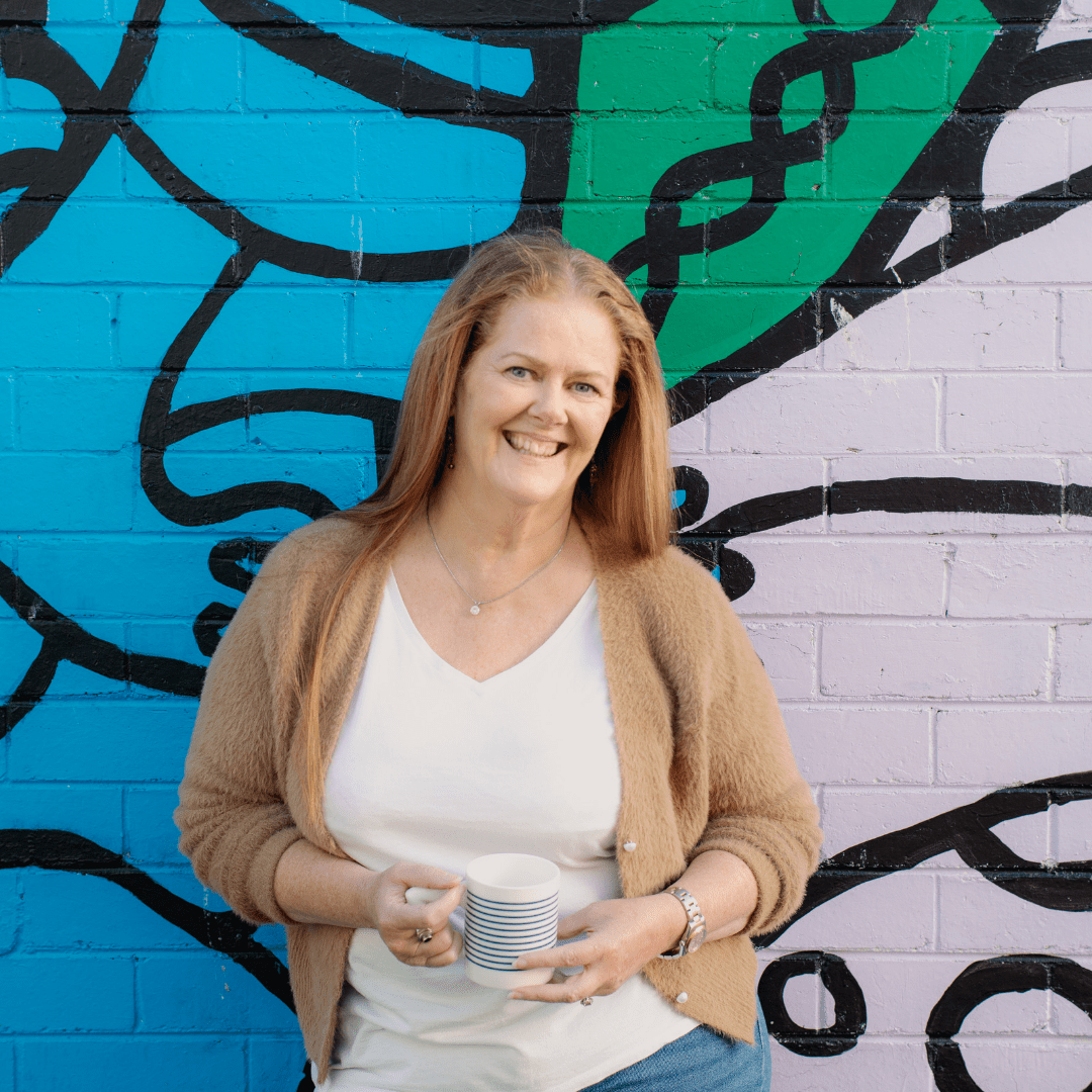 Donna leaning against a graffiti art wall in Frankston