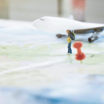 Local SEO - Mini figure traveler with red pushpin and a map travel concept.